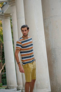 Güzel çocuk bermuda şortu ve çizgili gömleğiyle geziniyor. Yüksek kalite fotoğraf