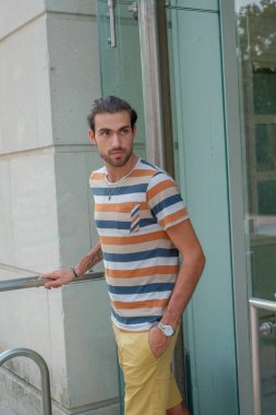 Güzel çocuk bermuda şortu ve çizgili gömleğiyle geziniyor. Yüksek kalite fotoğraf