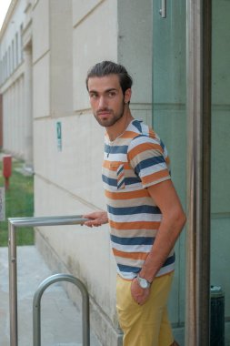 Güzel çocuk bermuda şortu ve çizgili gömleğiyle geziniyor. Yüksek kalite fotoğraf