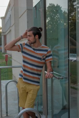 Güzel çocuk bermuda şortu ve çizgili gömleğiyle geziniyor. Yüksek kalite fotoğraf