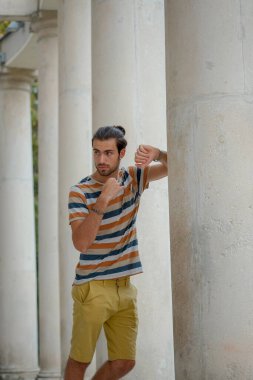 Güzel çocuk bermuda şortu ve çizgili gömleğiyle geziniyor. Yüksek kalite fotoğraf