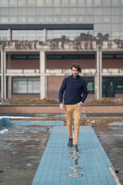 Yakışıklı, siyah saçlı İtalyan çocuk terk edilmiş fabrikada yürüyor. Yüksek kalite fotoğraf