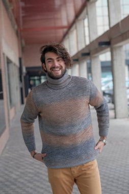 Ortasında çizgili süveter olan yakışıklı, siyah saçlı bir İtalyan. Yüksek kalite fotoğraf