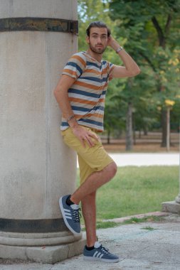 Güzel çocuk bermuda şortu ve çizgili gömleğiyle geziniyor. Yüksek kalite fotoğraf