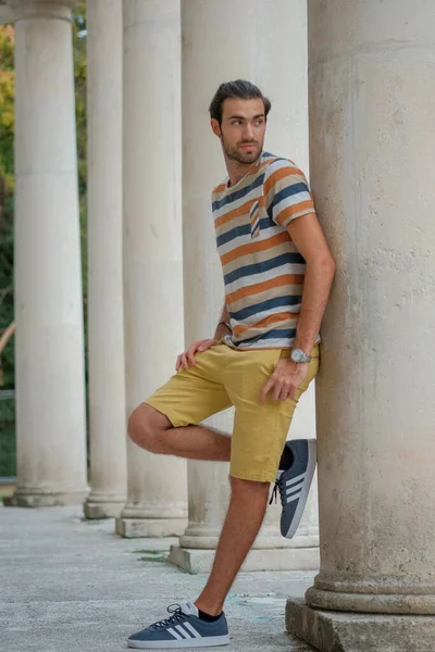 Güzel çocuk bermuda şortu ve çizgili gömleğiyle geziniyor. Yüksek kalite fotoğraf