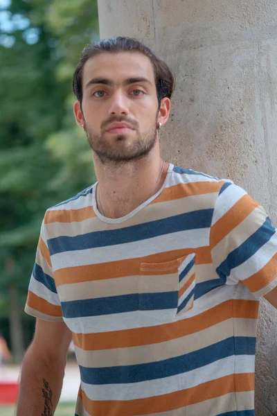 Güzel çocuk bermuda şortu ve çizgili gömleğiyle geziniyor. Yüksek kalite fotoğraf