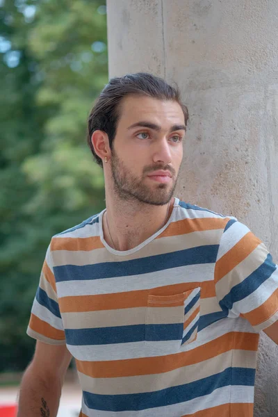 Güzel çocuk bermuda şortu ve çizgili gömleğiyle geziniyor. Yüksek kalite fotoğraf