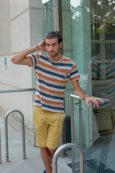 Güzel çocuk bermuda şortu ve çizgili gömleğiyle geziniyor. Yüksek kalite fotoğraf