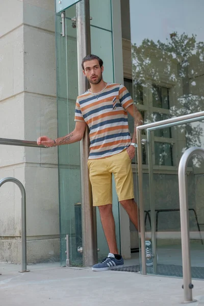 Güzel çocuk bermuda şortu ve çizgili gömleğiyle geziniyor. Yüksek kalite fotoğraf