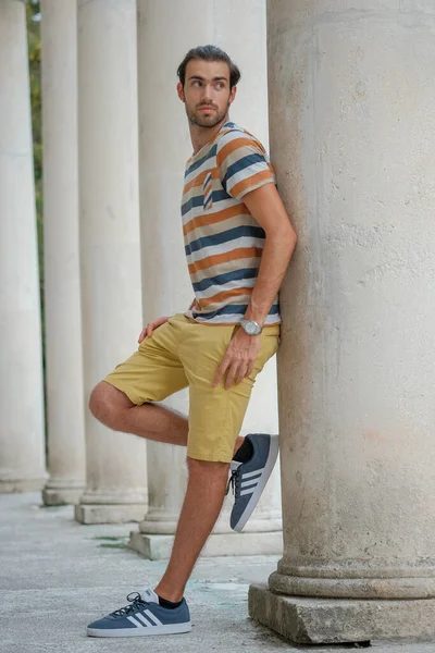 Güzel çocuk bermuda şortu ve çizgili gömleğiyle geziniyor. Yüksek kalite fotoğraf