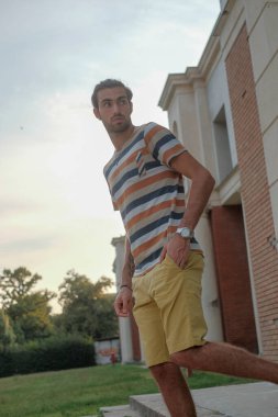 Güzel çocuk bermuda şortu ve çizgili gömleğiyle geziniyor. Yüksek kalite fotoğraf