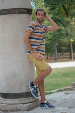 Güzel çocuk bermuda şortu ve çizgili gömleğiyle geziniyor. Yüksek kalite fotoğraf