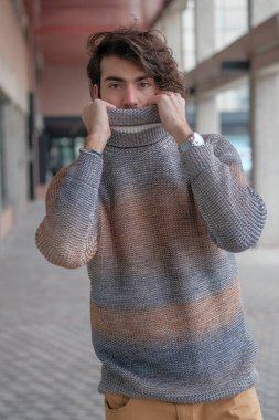 Ortasında çizgili süveter olan yakışıklı, siyah saçlı bir İtalyan. Yüksek kalite fotoğraf