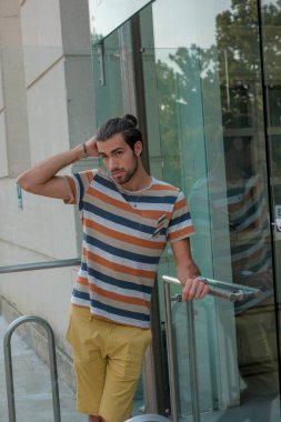 Güzel çocuk bermuda şortu ve çizgili gömleğiyle geziniyor. Yüksek kalite fotoğraf