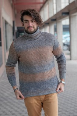 Ortasında çizgili süveter olan yakışıklı, siyah saçlı bir İtalyan. Yüksek kalite fotoğraf