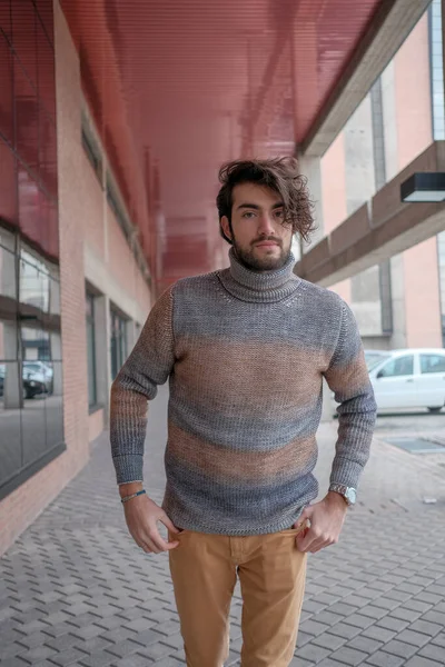 Ortasında çizgili süveter olan yakışıklı, siyah saçlı bir İtalyan. Yüksek kalite fotoğraf