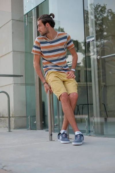 Güzel çocuk bermuda şortu ve çizgili gömleğiyle geziniyor. Yüksek kalite fotoğraf