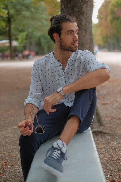 在帕尔马Ducale公园的长椅上坐着一位英俊的意大利黑头发男孩 他穿着衬衫 高质量的照片 — 图库照片