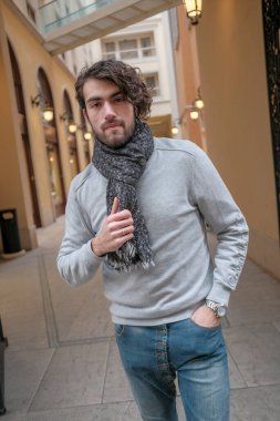 Süveteri ve atkısı olan yakışıklı, koyu renk saçlı bir İtalyan. Yüksek kalite fotoğraf