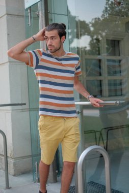 Güzel çocuk bermuda şortu ve çizgili gömleğiyle geziniyor. Yüksek kalite fotoğraf