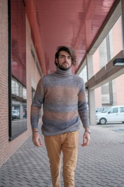 Ortasında çizgili süveter olan yakışıklı, siyah saçlı bir İtalyan. Yüksek kalite fotoğraf