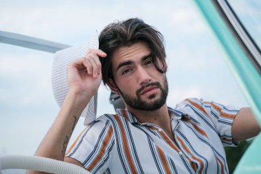 Çizgili gömlekli yakışıklı, koyu renk saçlı adam. Yüksek kalite fotoğraf