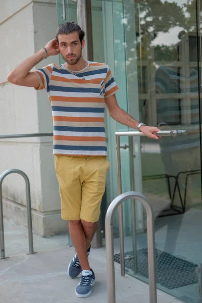 Güzel çocuk bermuda şortu ve çizgili gömleğiyle geziniyor. Yüksek kalite fotoğraf