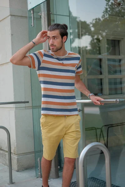 Güzel çocuk bermuda şortu ve çizgili gömleğiyle geziniyor. Yüksek kalite fotoğraf