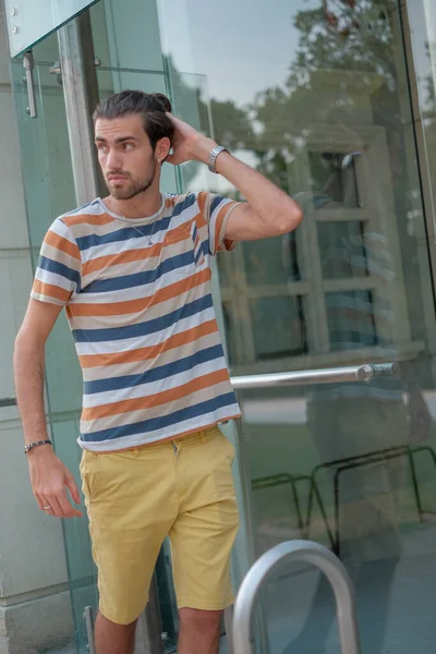 Güzel çocuk bermuda şortu ve çizgili gömleğiyle geziniyor. Yüksek kalite fotoğraf