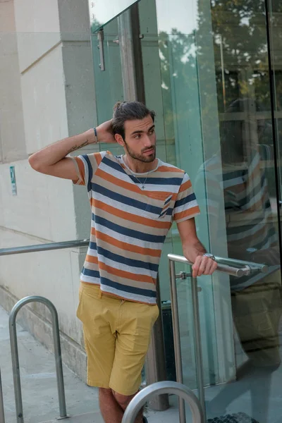 Güzel çocuk bermuda şortu ve çizgili gömleğiyle geziniyor. Yüksek kalite fotoğraf