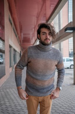 Ortasında çizgili süveter olan yakışıklı, siyah saçlı bir İtalyan. Yüksek kalite fotoğraf