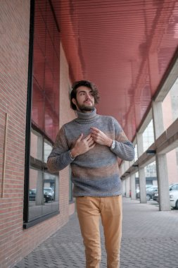 Ortasında çizgili süveter olan yakışıklı, siyah saçlı bir İtalyan. Yüksek kalite fotoğraf