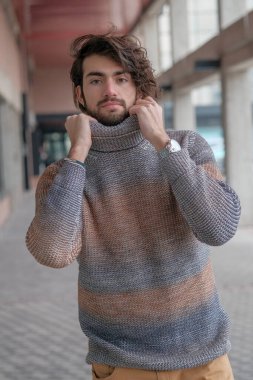 Ortasında çizgili süveter olan yakışıklı, siyah saçlı bir İtalyan. Yüksek kalite fotoğraf