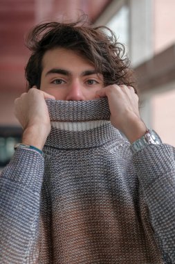 Ortasında çizgili süveter olan yakışıklı, siyah saçlı bir İtalyan. Yüksek kalite fotoğraf