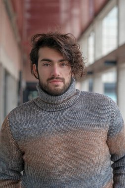 Ortasında çizgili süveter olan yakışıklı, siyah saçlı bir İtalyan. Yüksek kalite fotoğraf