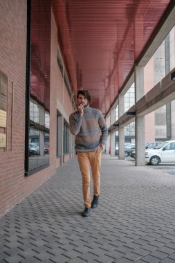 Ortasında çizgili süveter olan yakışıklı, siyah saçlı bir İtalyan. Yüksek kalite fotoğraf