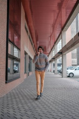 Ortasında çizgili süveter olan yakışıklı, siyah saçlı bir İtalyan. Yüksek kalite fotoğraf