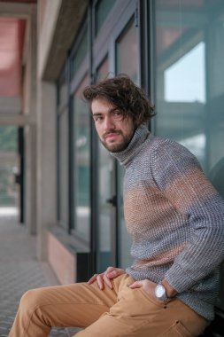 Ortasında çizgili süveter olan yakışıklı, siyah saçlı bir İtalyan. Yüksek kalite fotoğraf