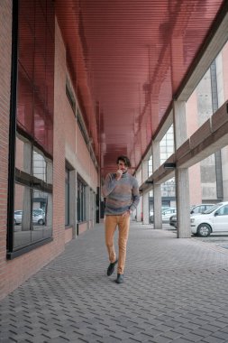 Ortasında çizgili süveter olan yakışıklı, siyah saçlı bir İtalyan. Yüksek kalite fotoğraf