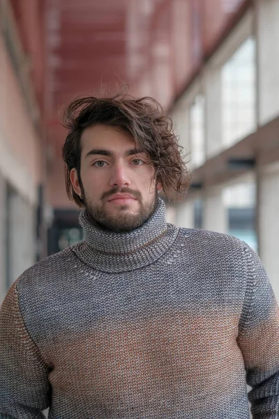 Ortasında çizgili süveter olan yakışıklı, siyah saçlı bir İtalyan. Yüksek kalite fotoğraf