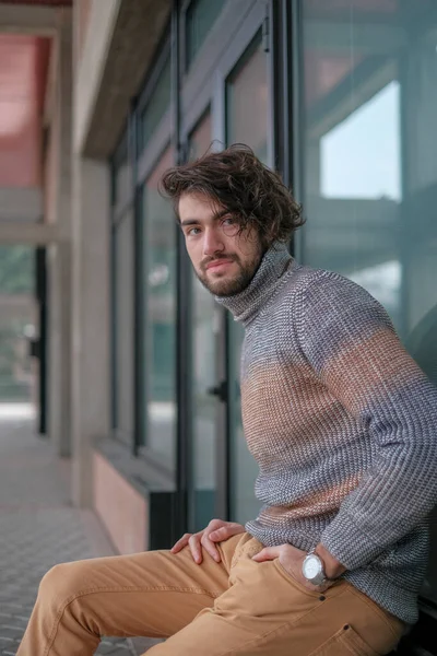 Ortasında çizgili süveter olan yakışıklı, siyah saçlı bir İtalyan. Yüksek kalite fotoğraf