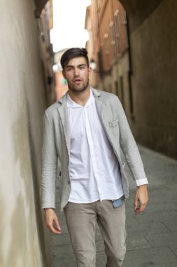 beautiful elegant Italian dark-haired boy strolls through the historic center. High quality photo