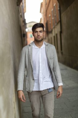 beautiful elegant Italian dark-haired boy strolls through the historic center. High quality photo