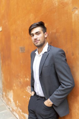 Güzel, siyah saçlı, kırmızı duvarlı, zarif İtalyan bir adam. Yüksek kalite fotoğraf