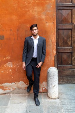 Güzel, siyah saçlı, kırmızı duvarlı, zarif İtalyan bir adam. Yüksek kalite fotoğraf