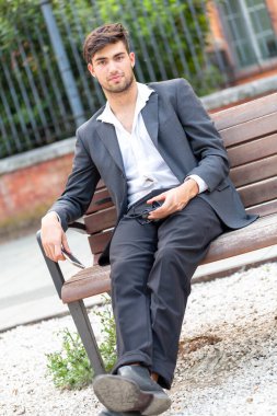 Tahta bankta oturan güzel siyah saçlı İtalyan çocuk. Yüksek kalite fotoğraf