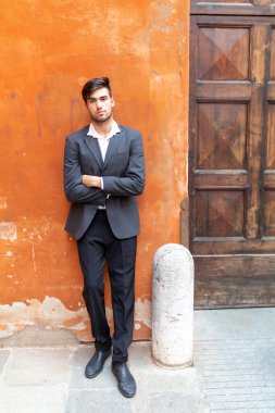 Güzel, siyah saçlı, kırmızı duvarlı, zarif İtalyan bir adam. Yüksek kalite fotoğraf