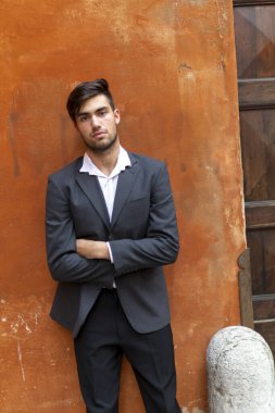 Güzel, siyah saçlı, kırmızı duvarlı, zarif İtalyan bir adam. Yüksek kalite fotoğraf