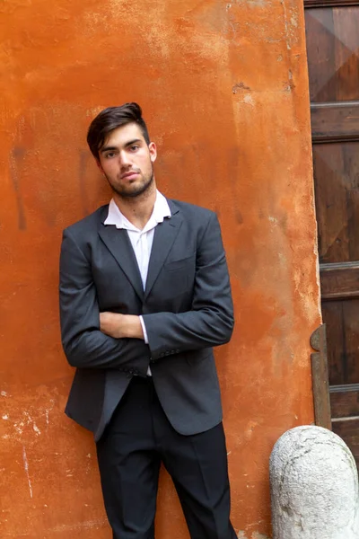 Güzel, siyah saçlı, kırmızı duvarlı, zarif İtalyan bir adam. Yüksek kalite fotoğraf