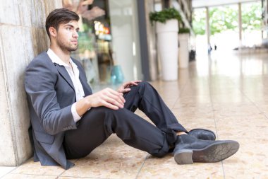 Güzel, siyah saçlı İtalyan çocuk şehir merkezinde yerde oturuyor. Yüksek kalite fotoğraf